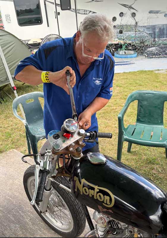 Ken Lavallee, CBE Race Works crew member repairs the damaged Norton Commando in the paddock at Canaan Motor Club